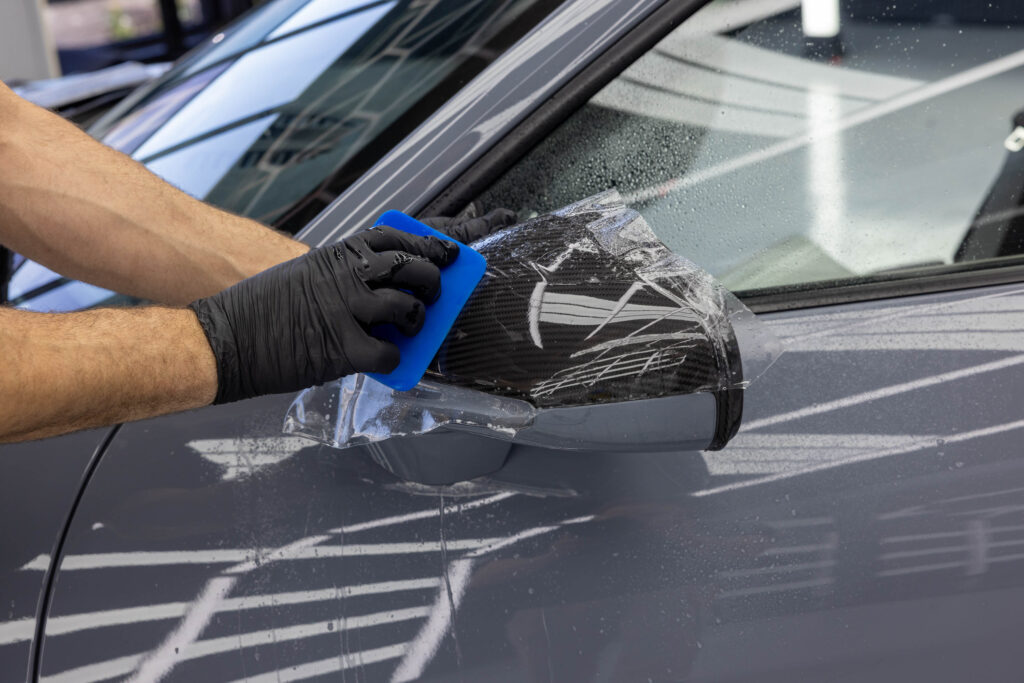 Aufziehen von PPF Schutzfolie auf Aussenspiegel von grauem Porsche GT3 RS