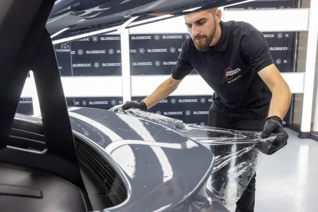 Aufziehen von PPF Schutzfolie auf Heckspoiler von grauem Porsche GT3 RS